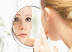 A blonde lady looking in the mirror for ageing skin